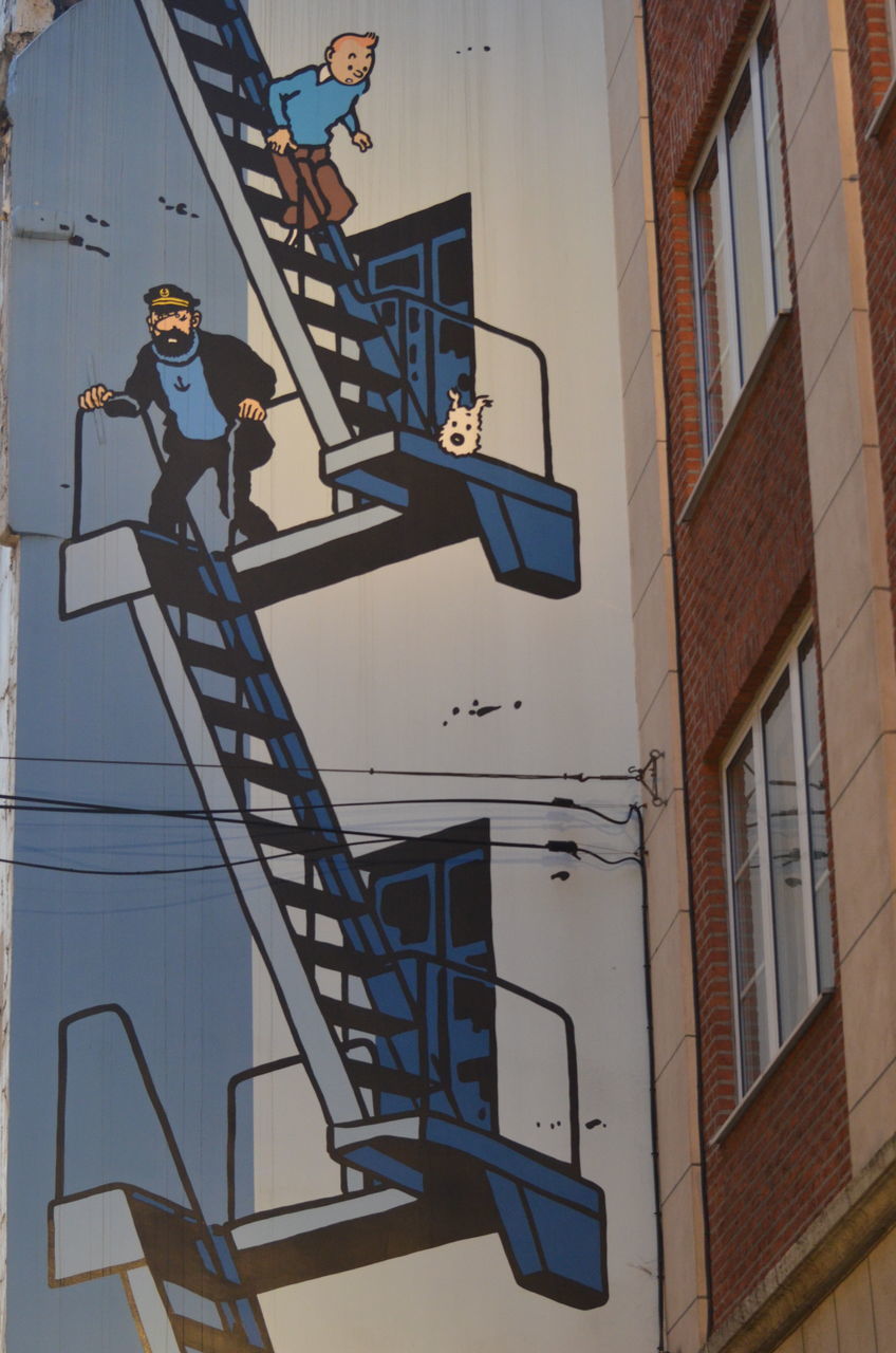 LOW ANGLE VIEW OF MAN ON BUILDING AGAINST SKY