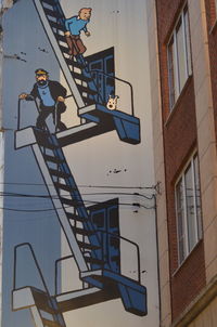 Low angle view of man on staircase against building