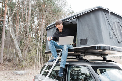Man working from a home office in a tent whilst social distancing