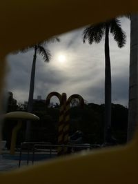 Silhouette palm trees against sky at sunset