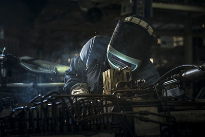 Worker welding at factory