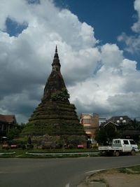 Cars on road against cloudy sky