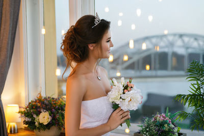 Side view of young woman with bouquet