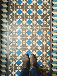 Low section of person standing on tiled floor