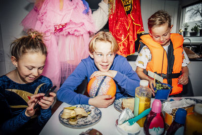 Male and female siblings sitting at table in morning