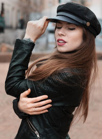 Young woman wearing hat while standing outdoors