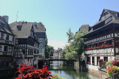 Buildings by river against clear sky