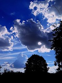 Silhouette of trees against cloudy sky