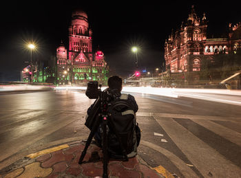 Rear view of woman walking on road at night