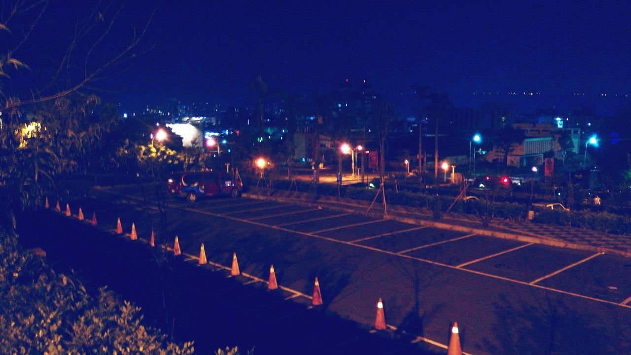 illuminated, night, clear sky, street light, building exterior, tree, sky, built structure, transportation, blue, high angle view, architecture, road, outdoors, dusk, lighting equipment, city, street, copy space, no people