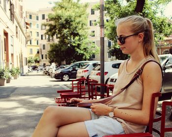 Woman sitting on sidewalk