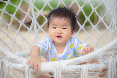 Portrait of cute baby girl behind fence