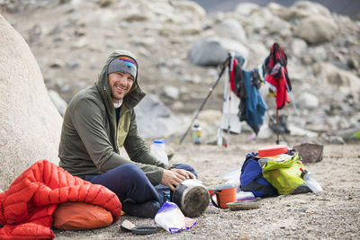 Portrait of climber sitting down for a meal at camp.