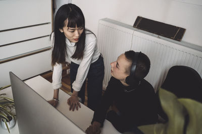 Businesswomen talking while working on computer at workplace