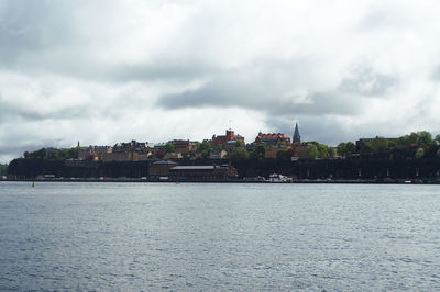 Scenic view of sea by buildings against sky