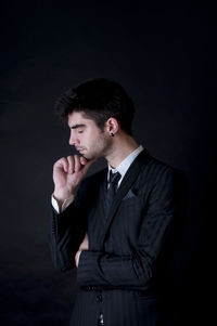 Young man looking away over black background