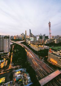 View of city at waterfront against cloudy sky