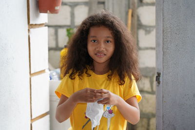 Portrait of smiling woman holding yellow while standing outdoors