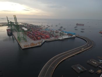 High angle view of commercial dock by sea against sky