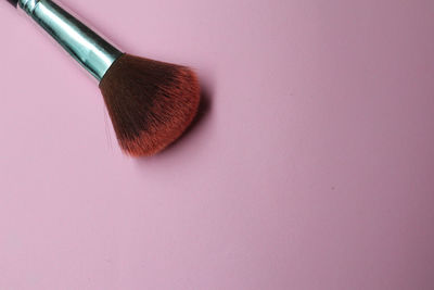 High angle view of paintbrushes on pink background