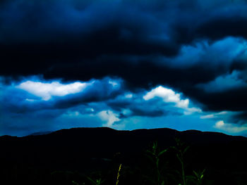 Silhouette of mountain against cloudy sky