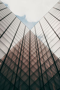 Low angle view of glass building against sky