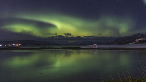 Scenic view of lake against 
aurora borealis at night