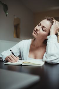 Portrait of teenage girl sitting on table at home