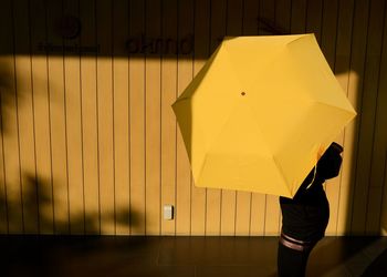 Low section of person holding umbrella in rain