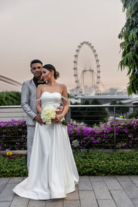 Portrait of bride and groom standing in park