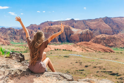 Full length of woman sitting on rock