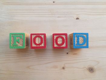 High angle view of toy blocks with text on wooden table