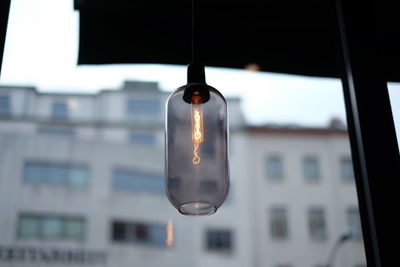 Low angle view of light bulb against glass window