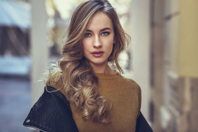 Portrait of young woman standing in city