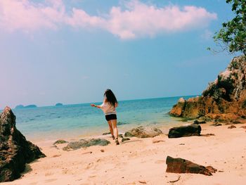 Rear view of woman standing on shore