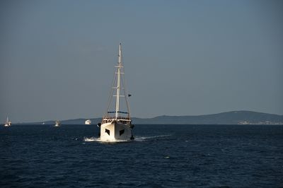 Lighthouse by sea against clear sky