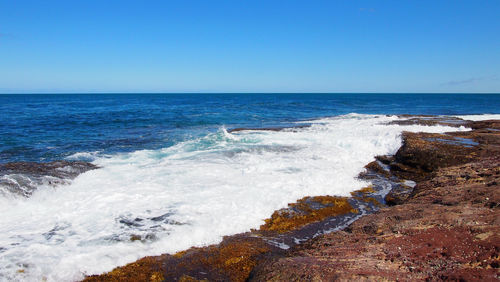 Scenic view of sea against clear blue sky