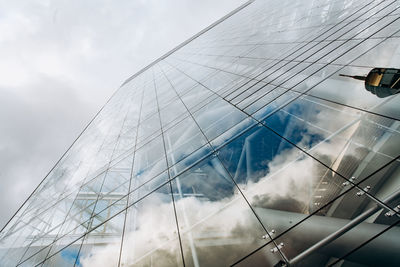 Low angle view of glass building against sky