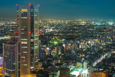 Illuminated cityscape against sky at night