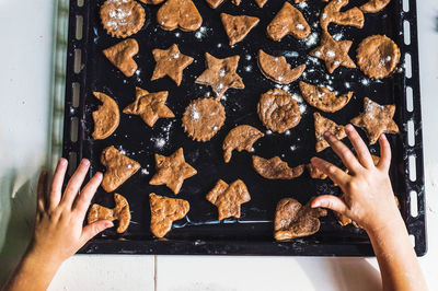 Cropped image of hands making cookies in tray