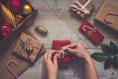 High angle view of woman holding christmas decoration on table