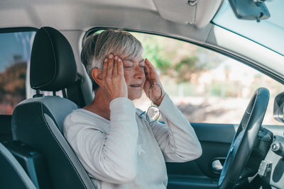 Side view of woman sitting in car