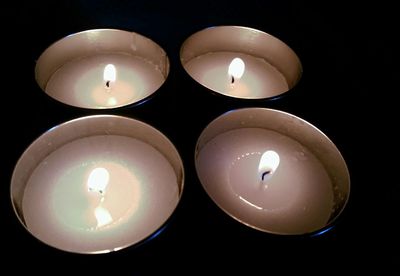 Close-up of lit candle in darkroom