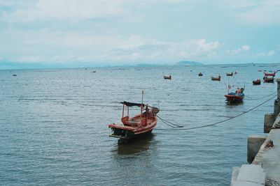 Boat moored in sea against sky