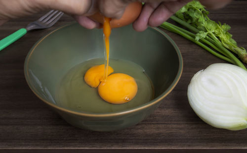 Cropped hand of person preparing food on table