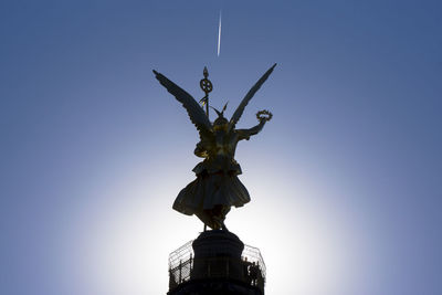 Low angle view of statue against clear blue sky