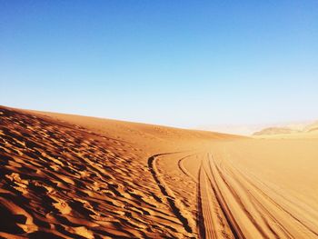 Scenic view of desert against clear blue sky