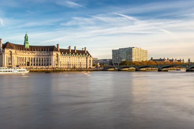 View of buildings at waterfront against cloudy sky