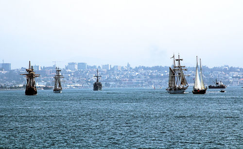 Boats in sea against clear sky