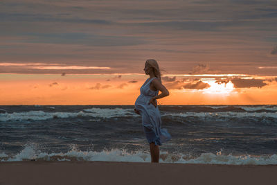 Pregnant woman on beach at sunset